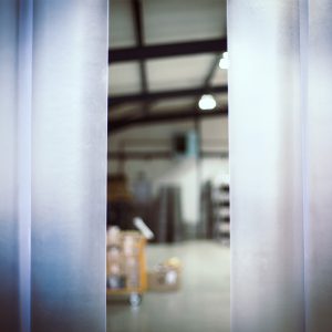 looking through frosted PVC strip curtains into a warehouse