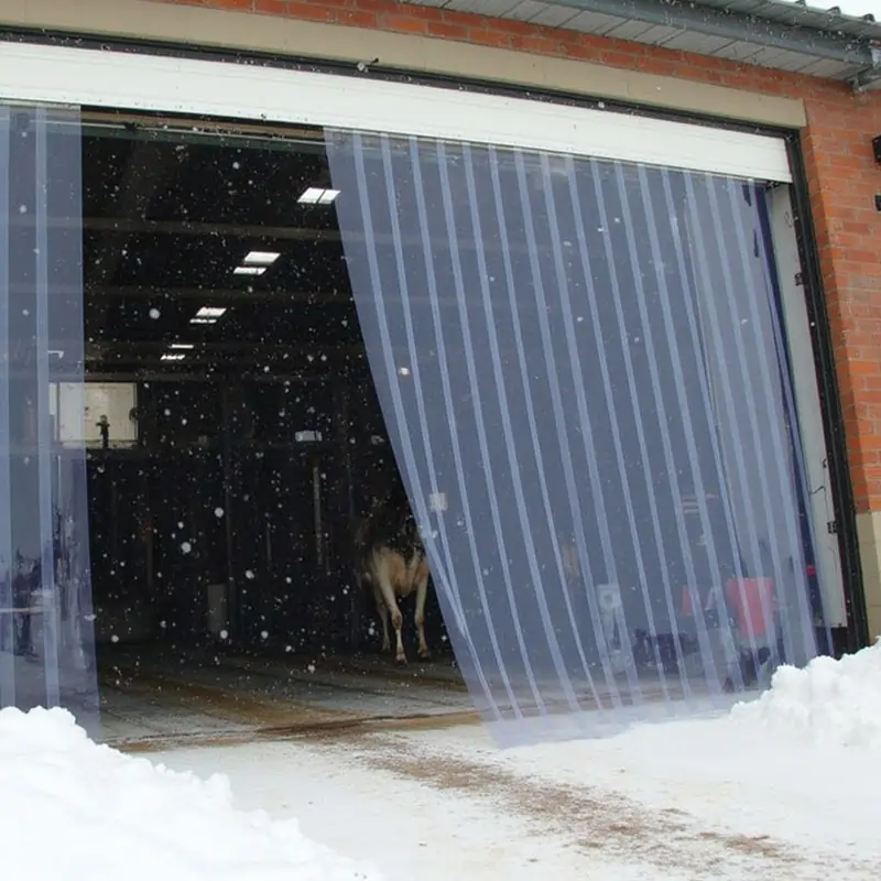 PVC strip curtains in the doorway of a warehouse with snow outside
